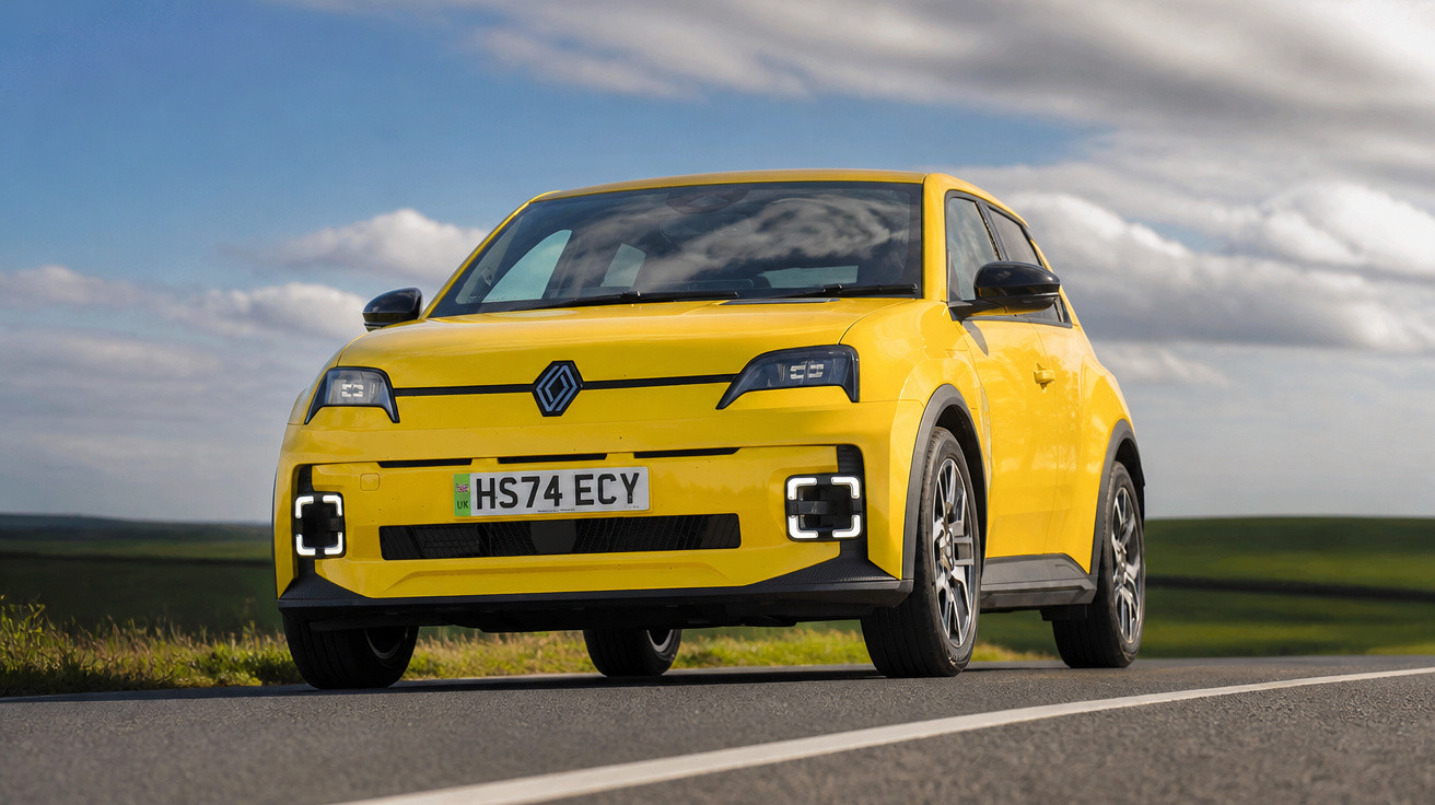 Yellow Renault electric car parked on countryside road under cloudy sky.
